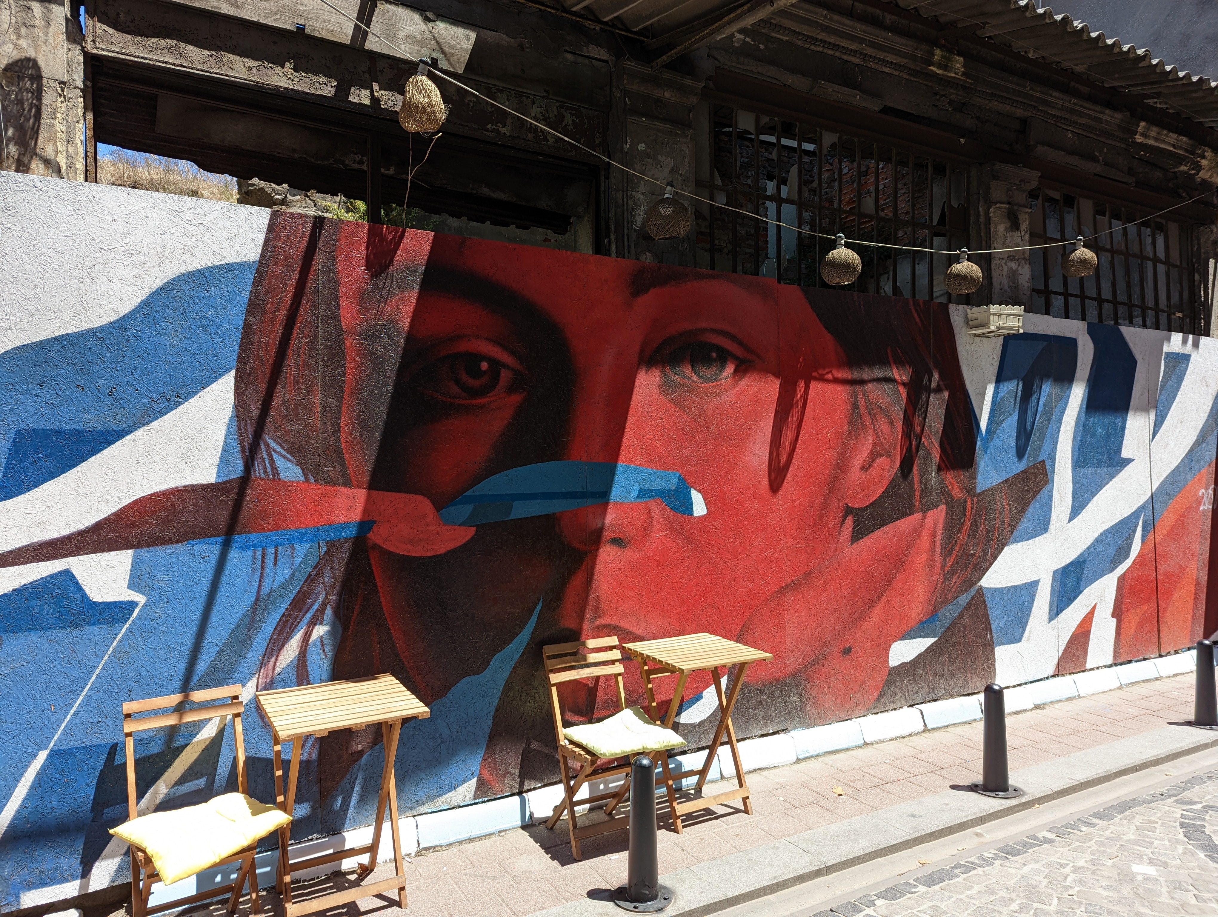 Street art featuring a red/blue face near Istanbul's Balat neighborhood.