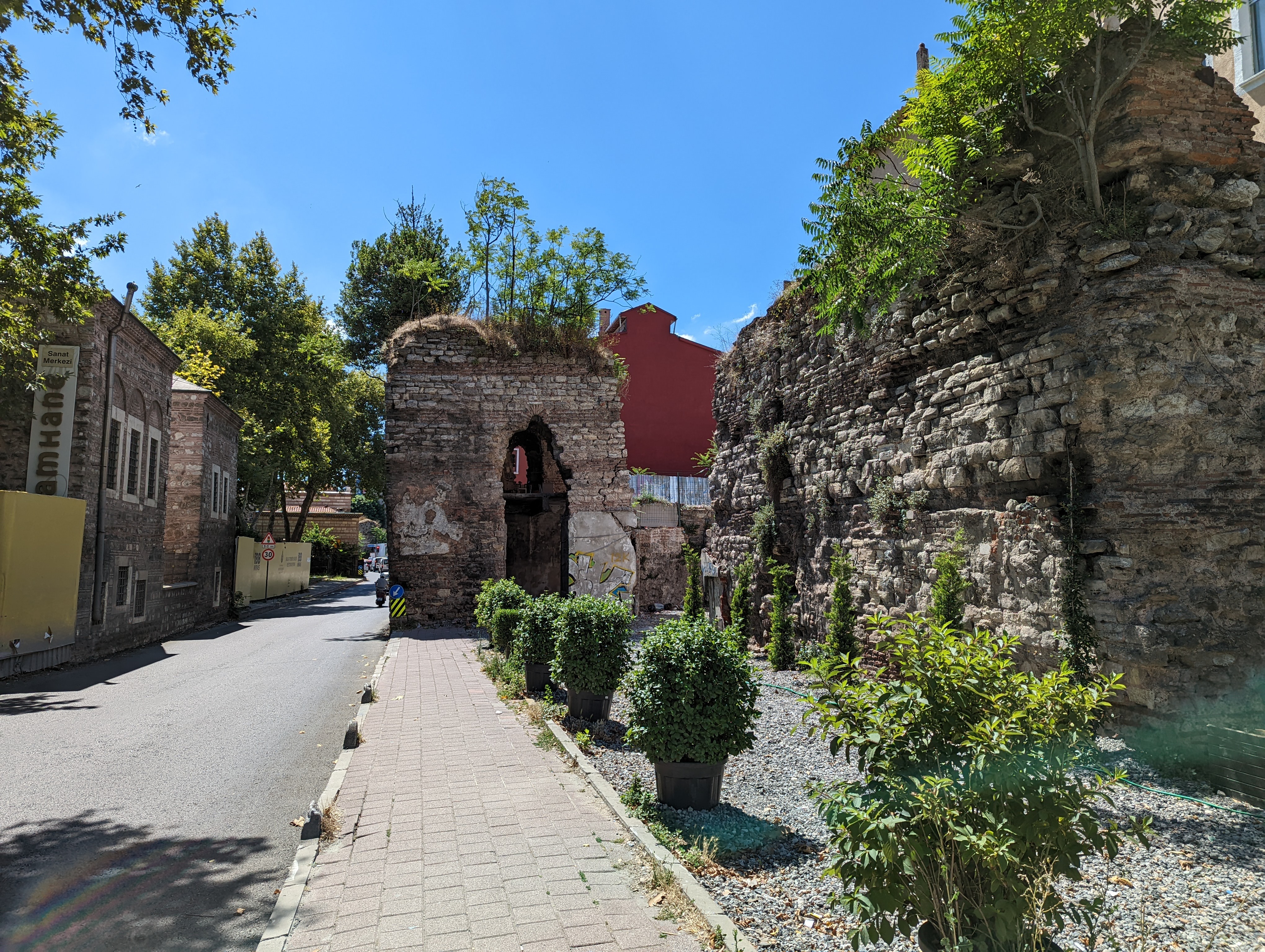 The remnants of ancient city walls stand beside roadways in Istanbul.