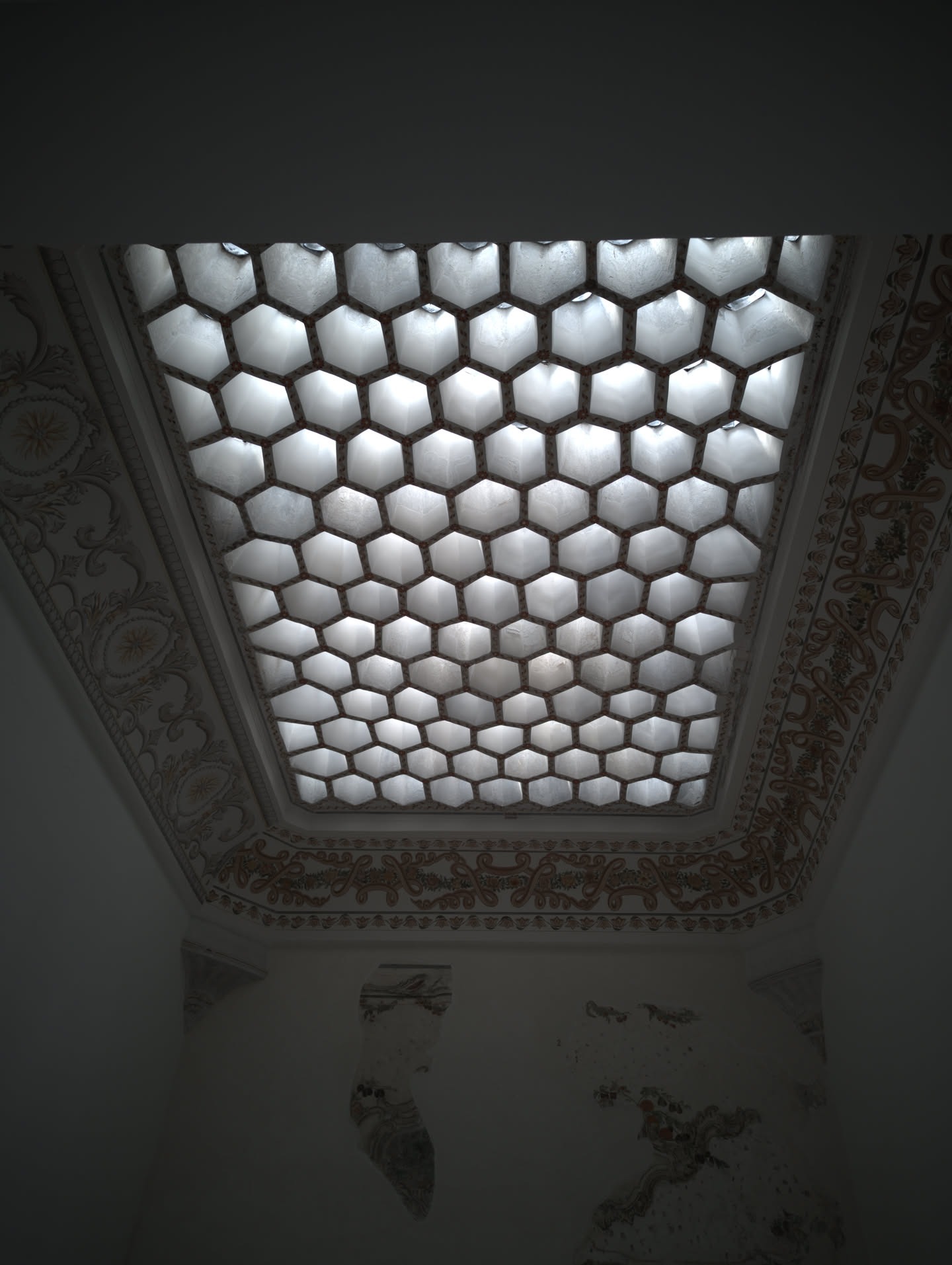 This is a view looking directly up at a honeycomb glass skylight (petekli aydınlık) set into the ceiling of a hallway/chamber within the Imperial Harem or the Baths of the Sultan and Queen Mother (Hünkâr ve Valide Sultan Hamamları) at Topkapı Palace.
