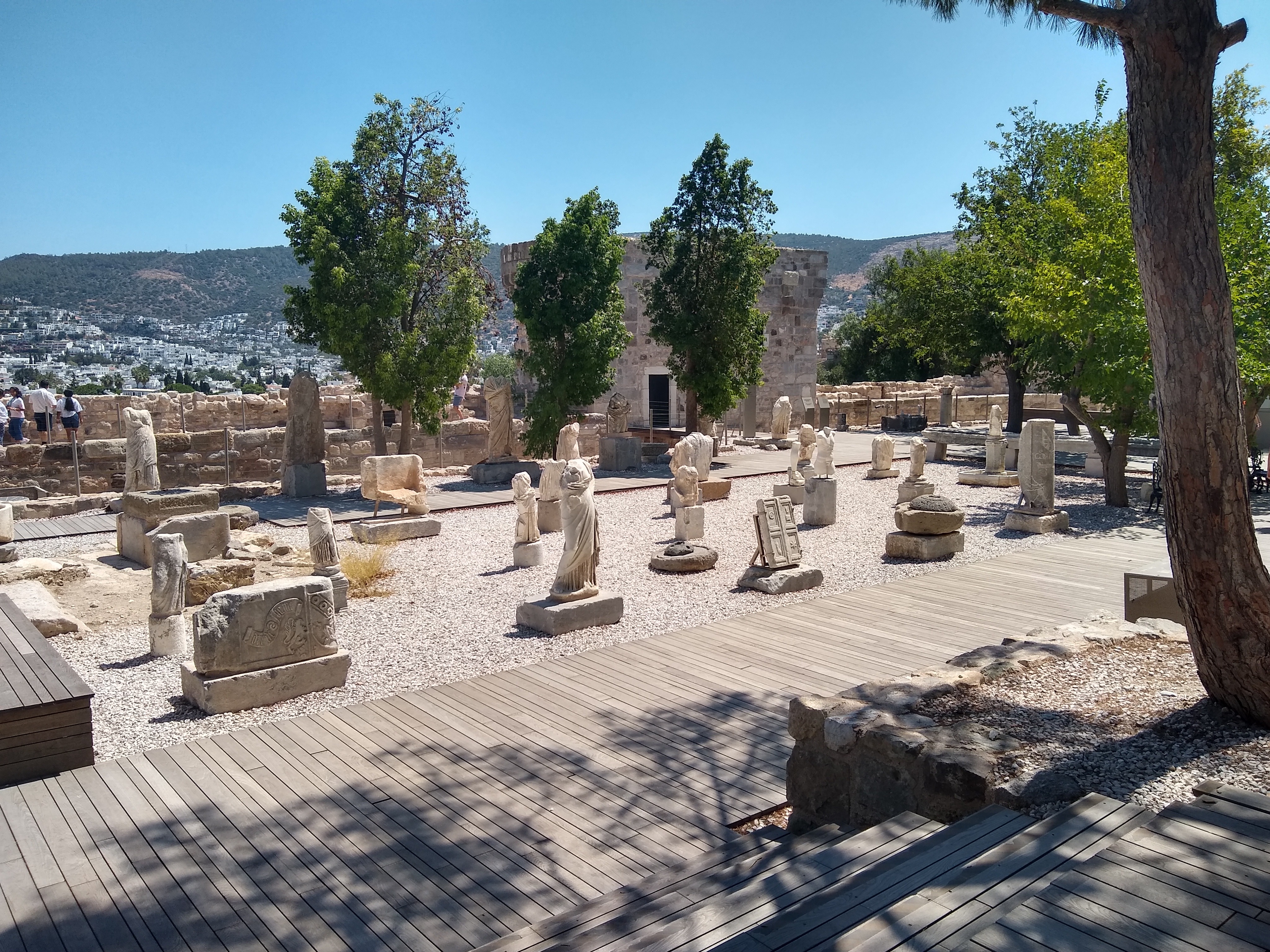 Stone sculptures and artifacts arranged on a gravel patio