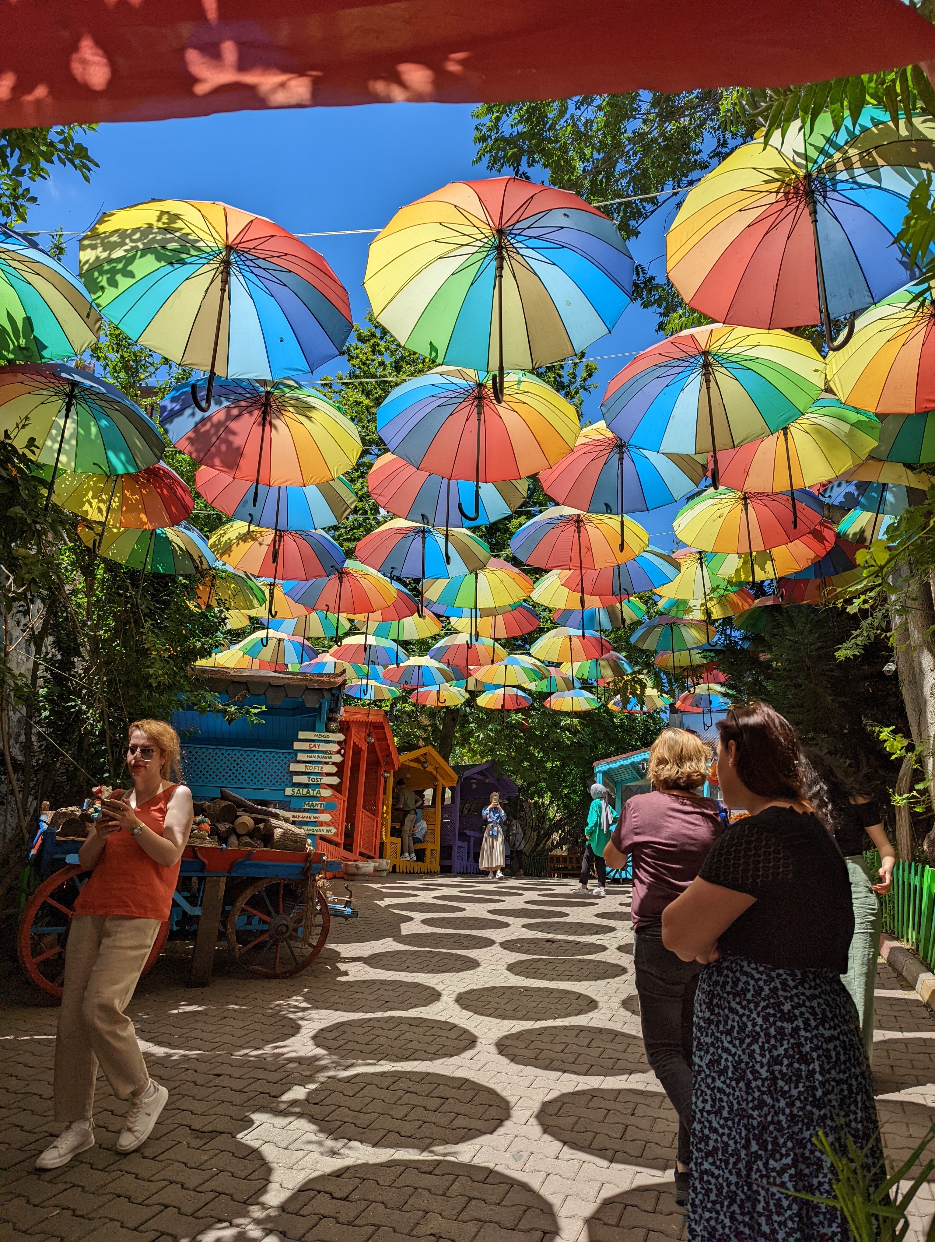 Colorful umbrellas suspended over streets offer respite from the hot sun in Istanbul's Balat neighborhood.