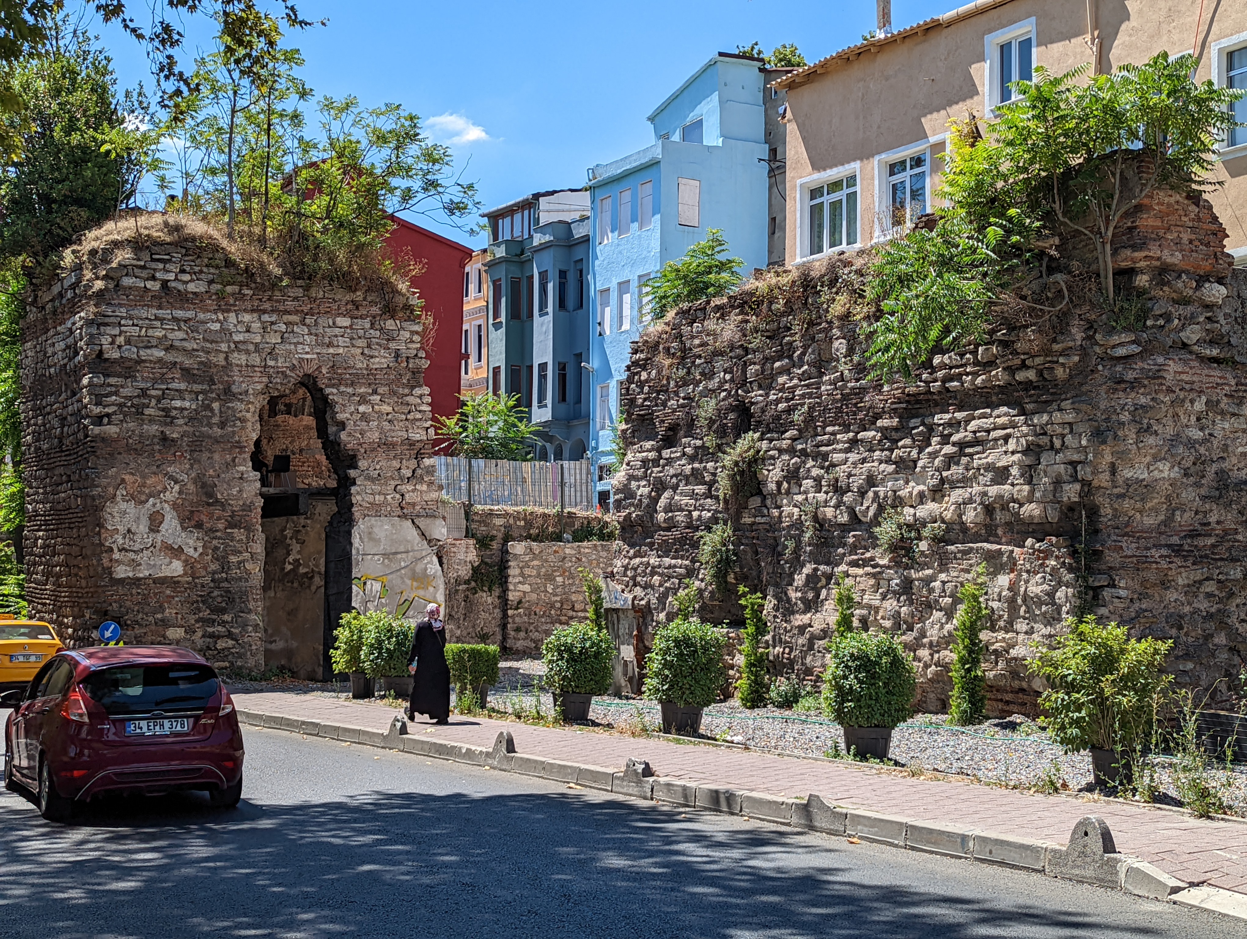 The remnants of ancient city walls stand beside roadways in Istanbul.