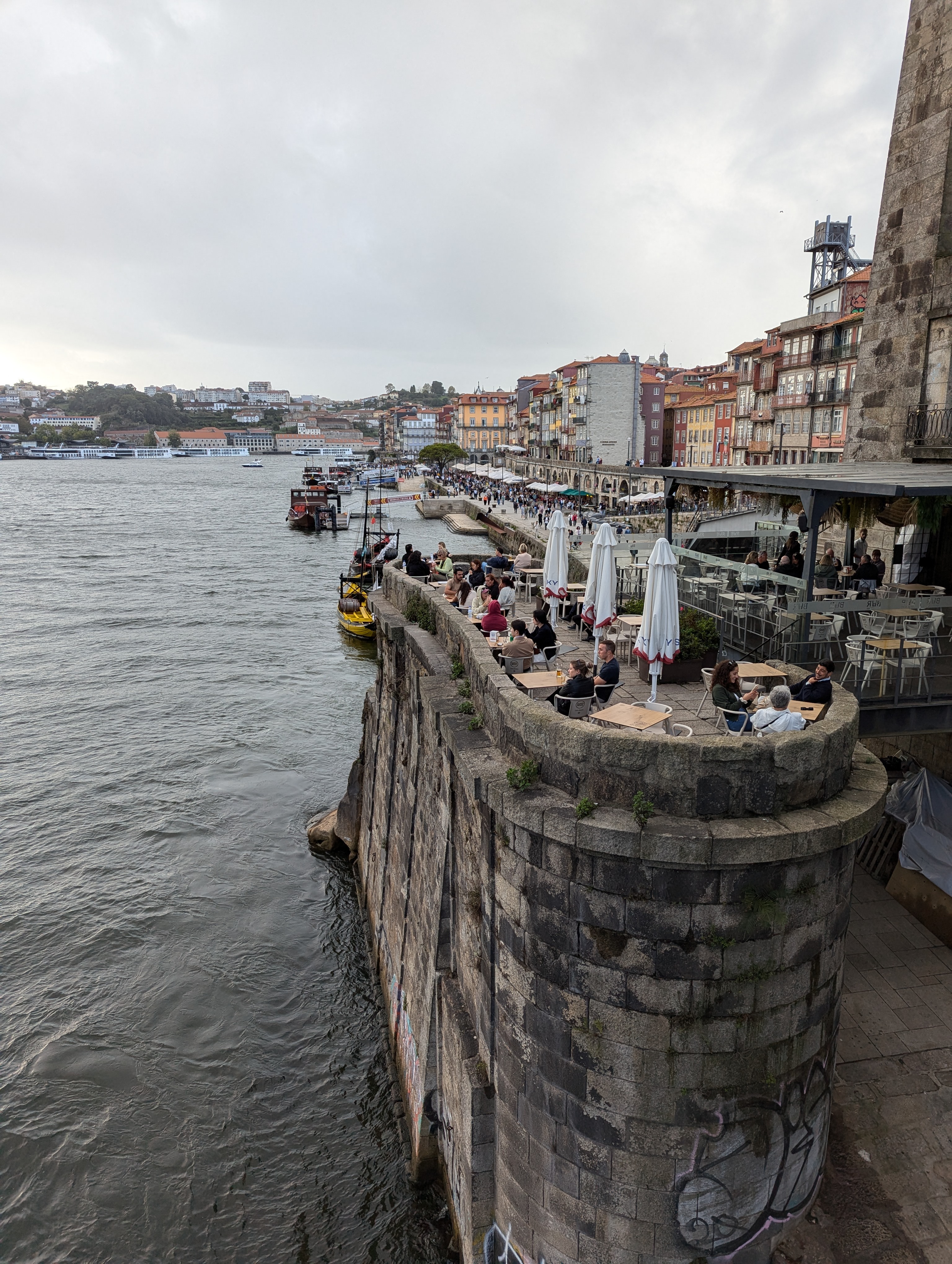 People dine on a stone outcropping looking out at the Douro river in Porto.