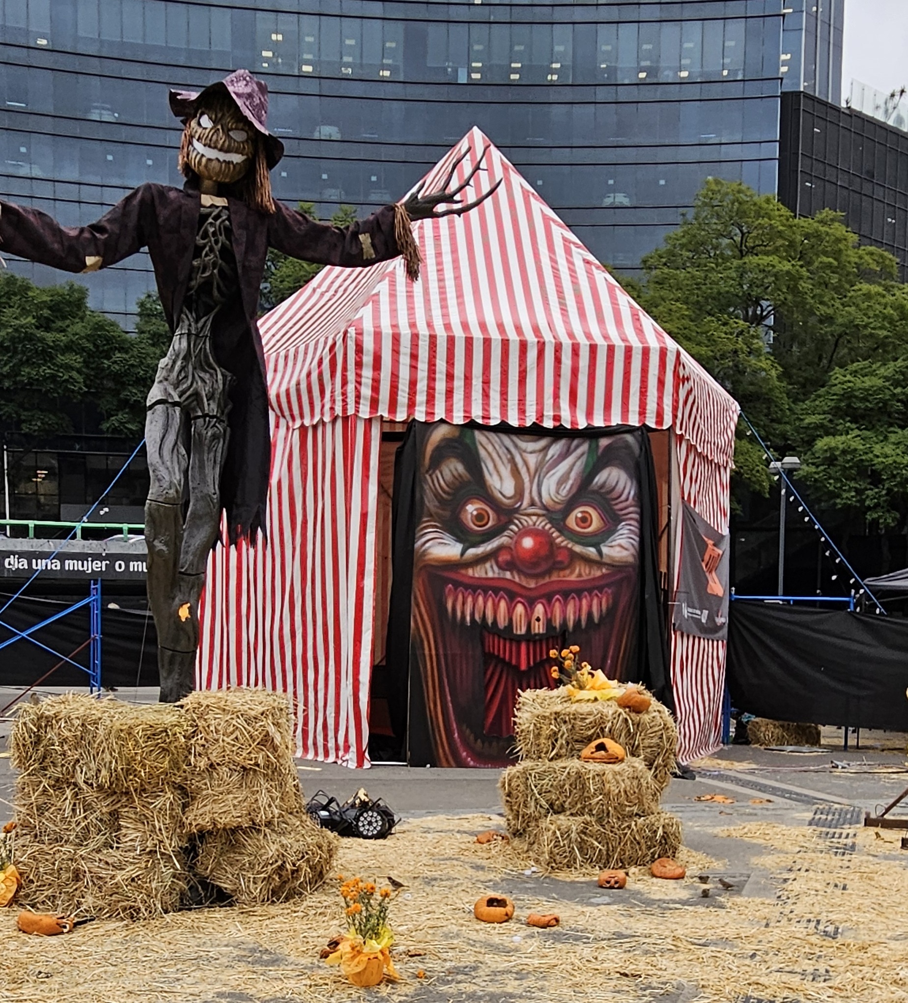 Straw bales, scary scarecrow, and tent with scary clown face
