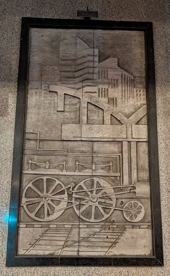 Relief carving of stylized train piston