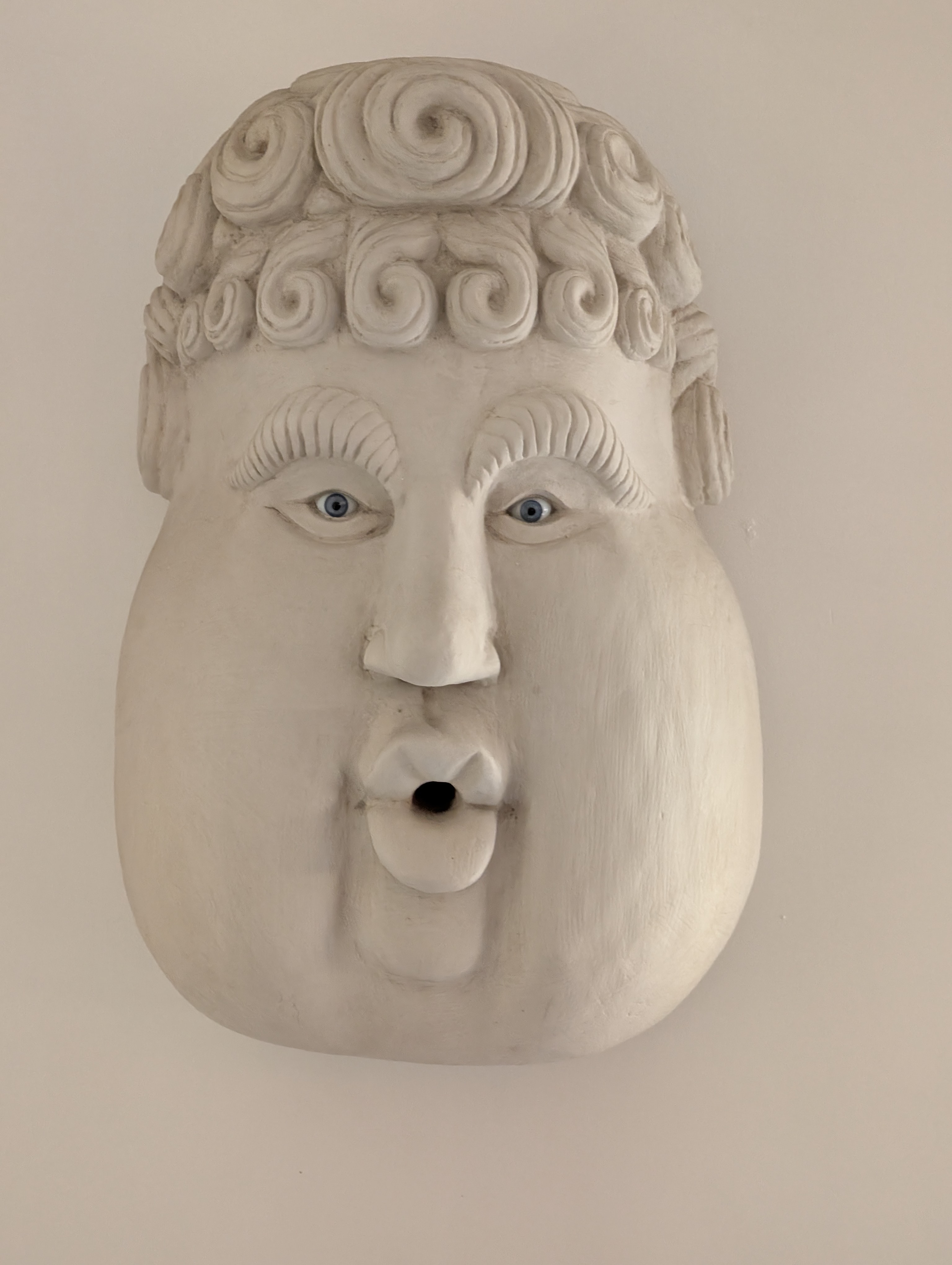 Quirky sculptural face appears to be whistling