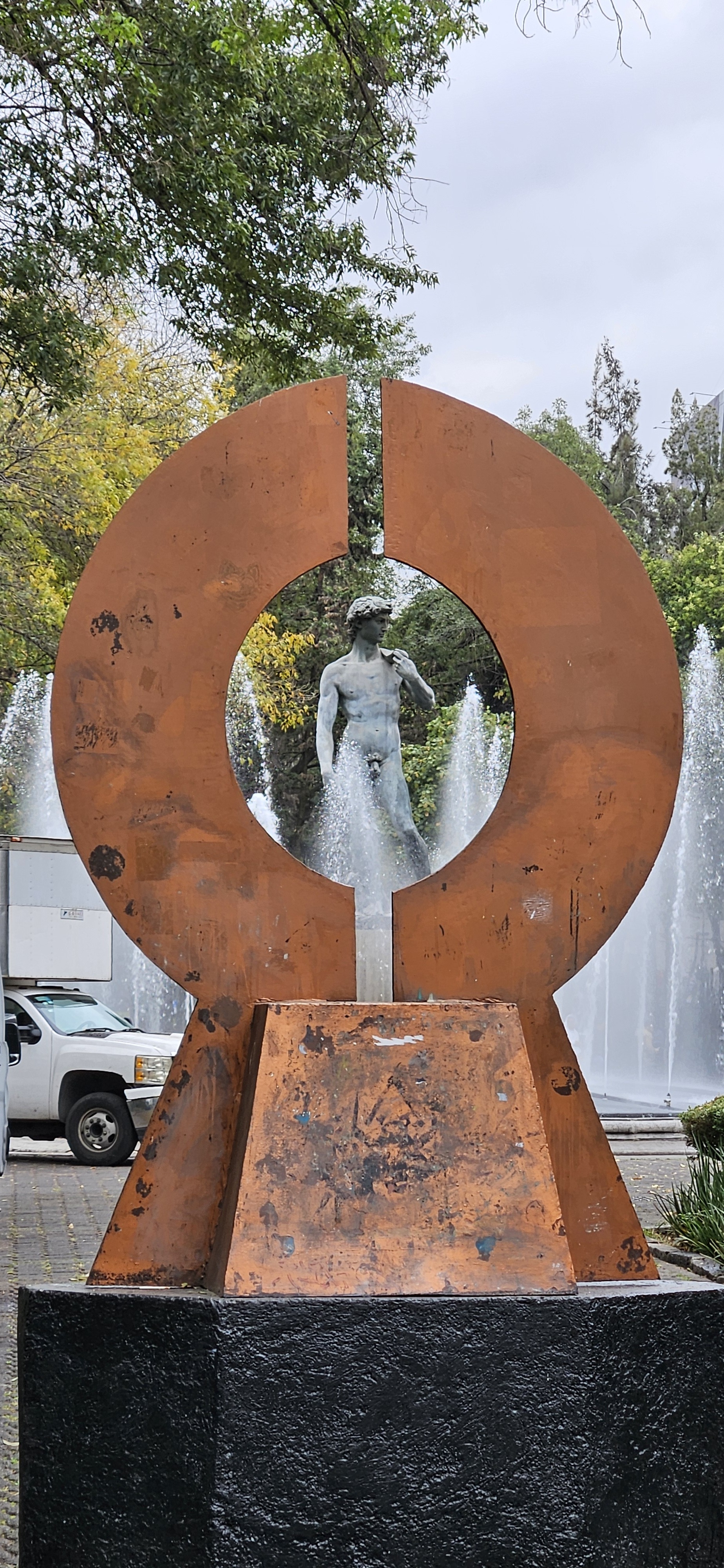 David statue and fountain seen through metal sculpture in Plaza Rio de Janeiro