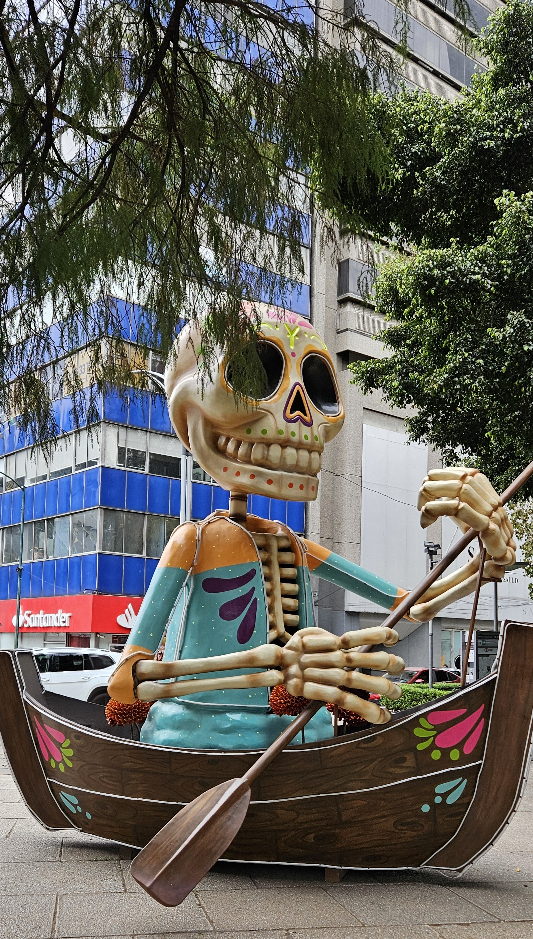 Skeleton paddling a boat street sculpture