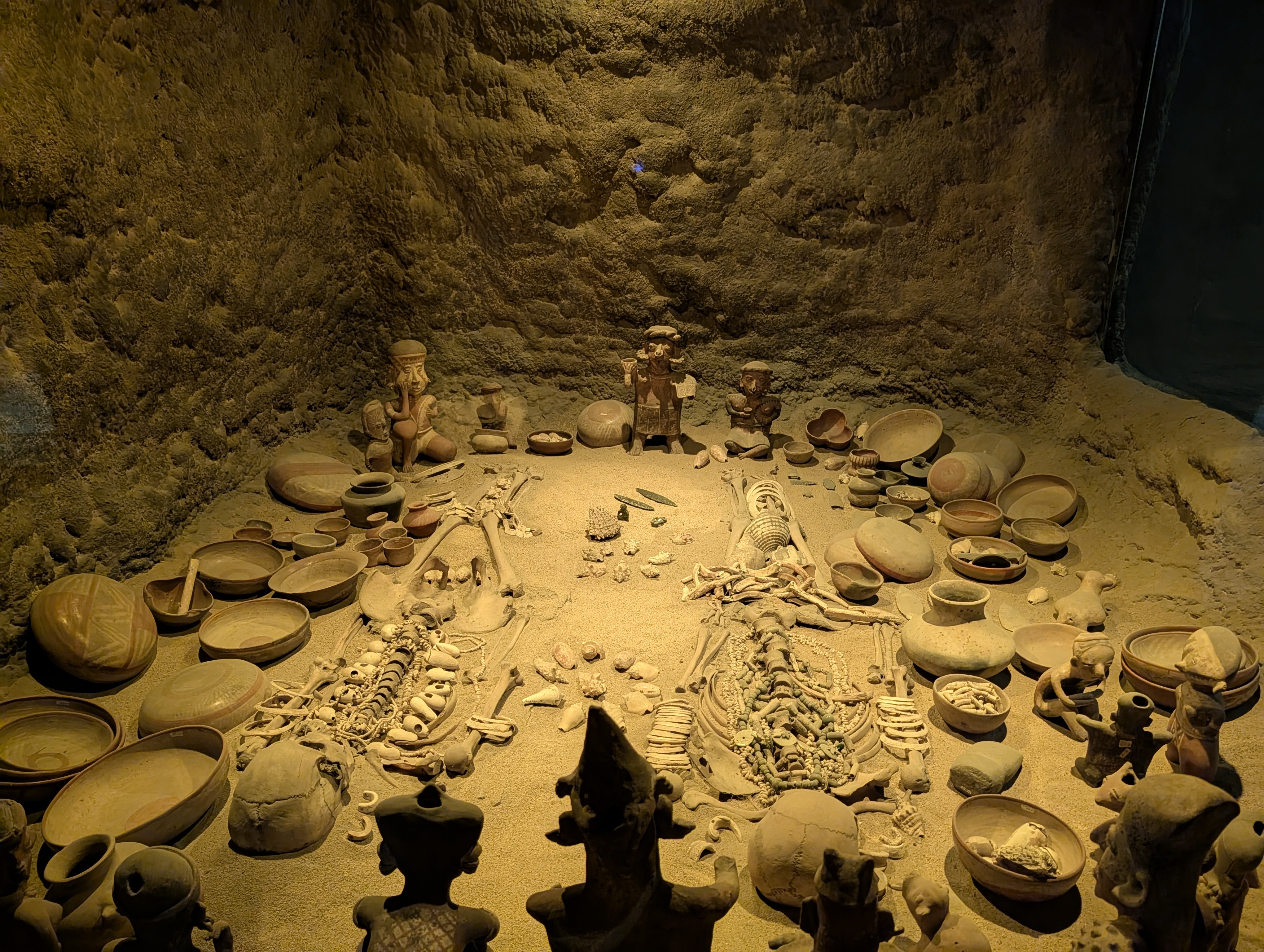 A replica of a burial site complete with skeletons and grave goods.