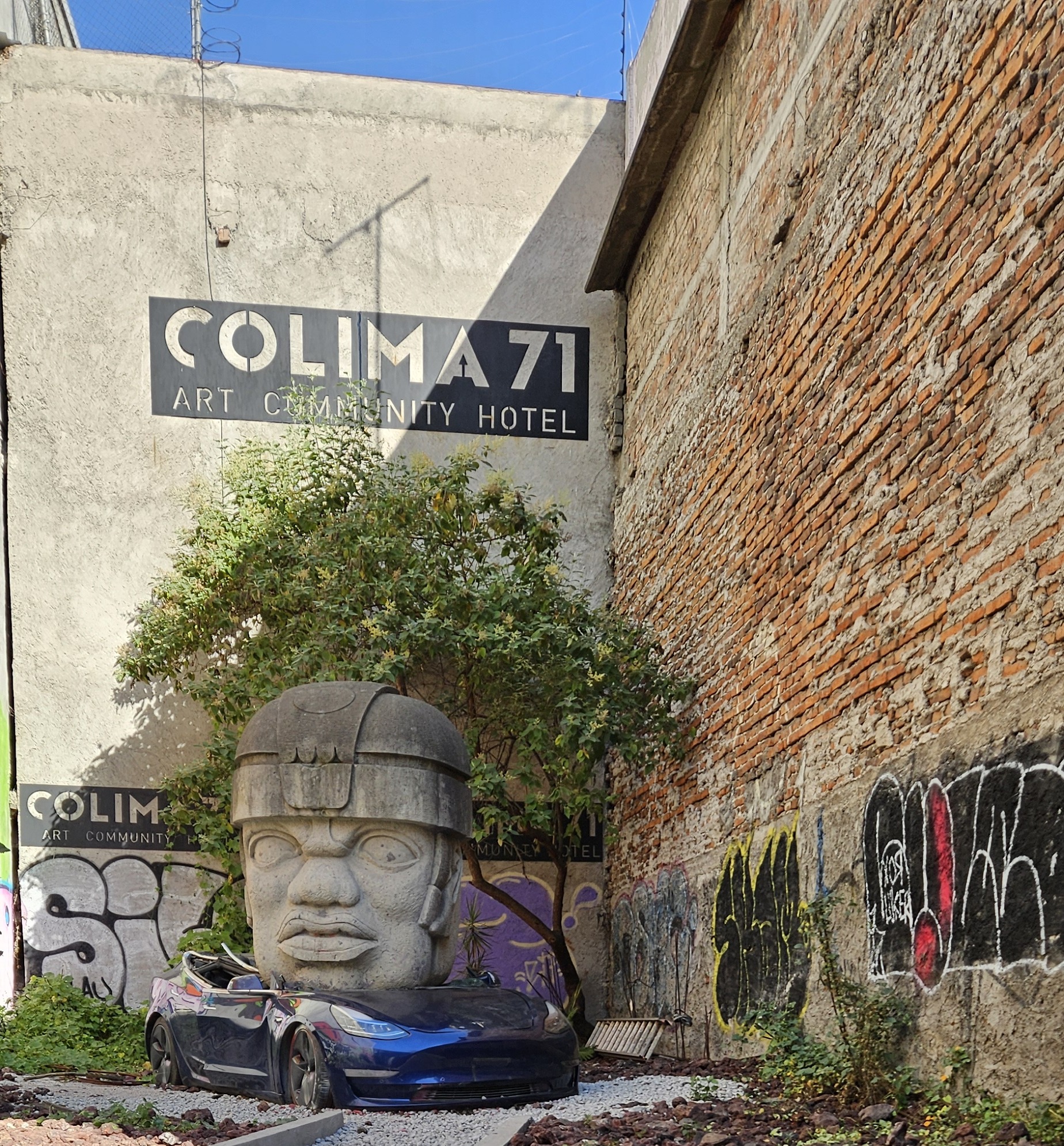 Giant head sculpture crushing a car