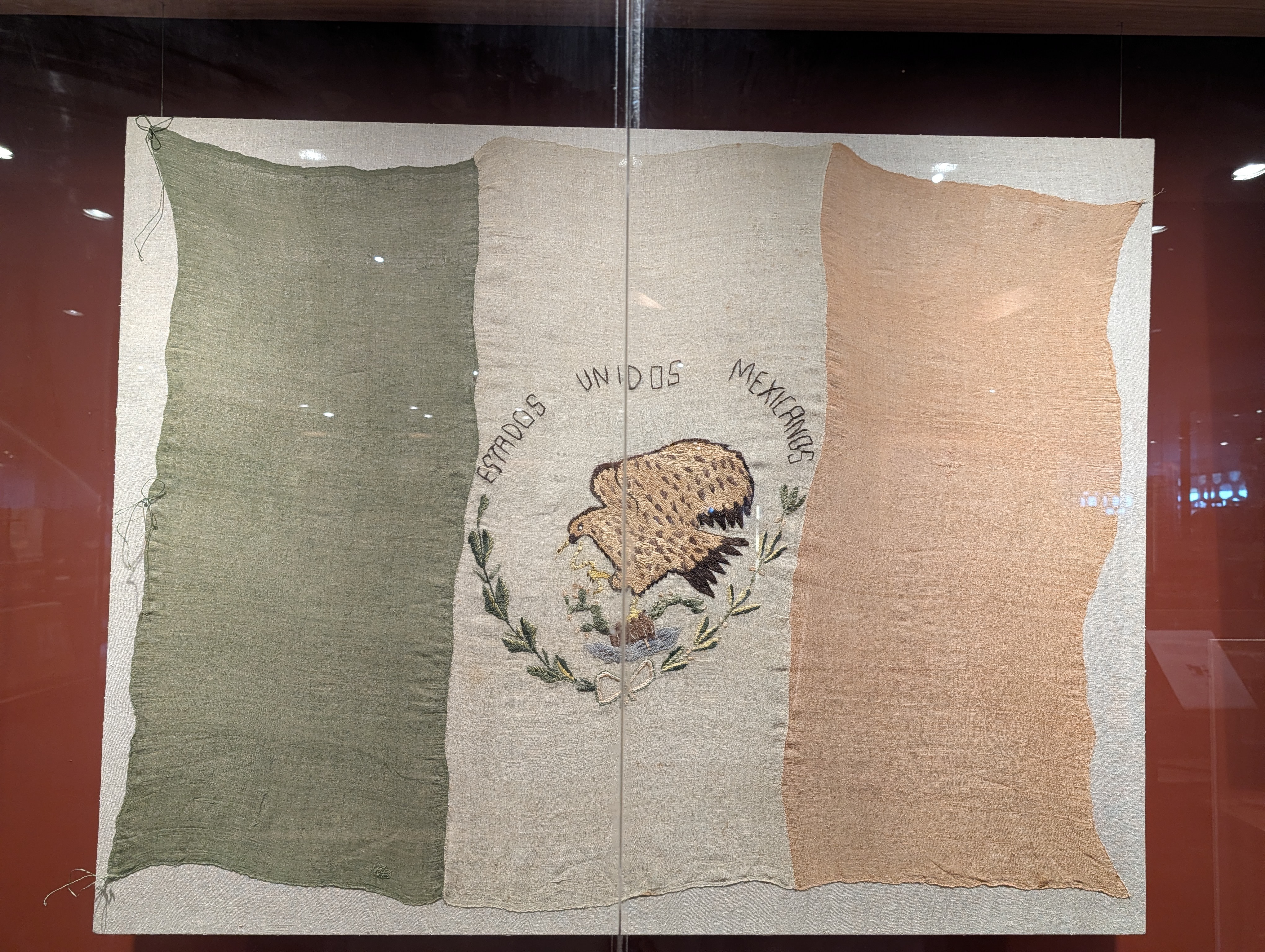 This is a historic Mexican national flag, hand-embroidered, showing the coat of arms.