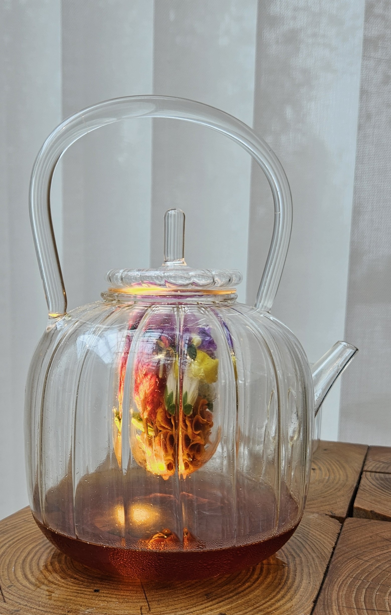 Glass teapot of cider and flowers