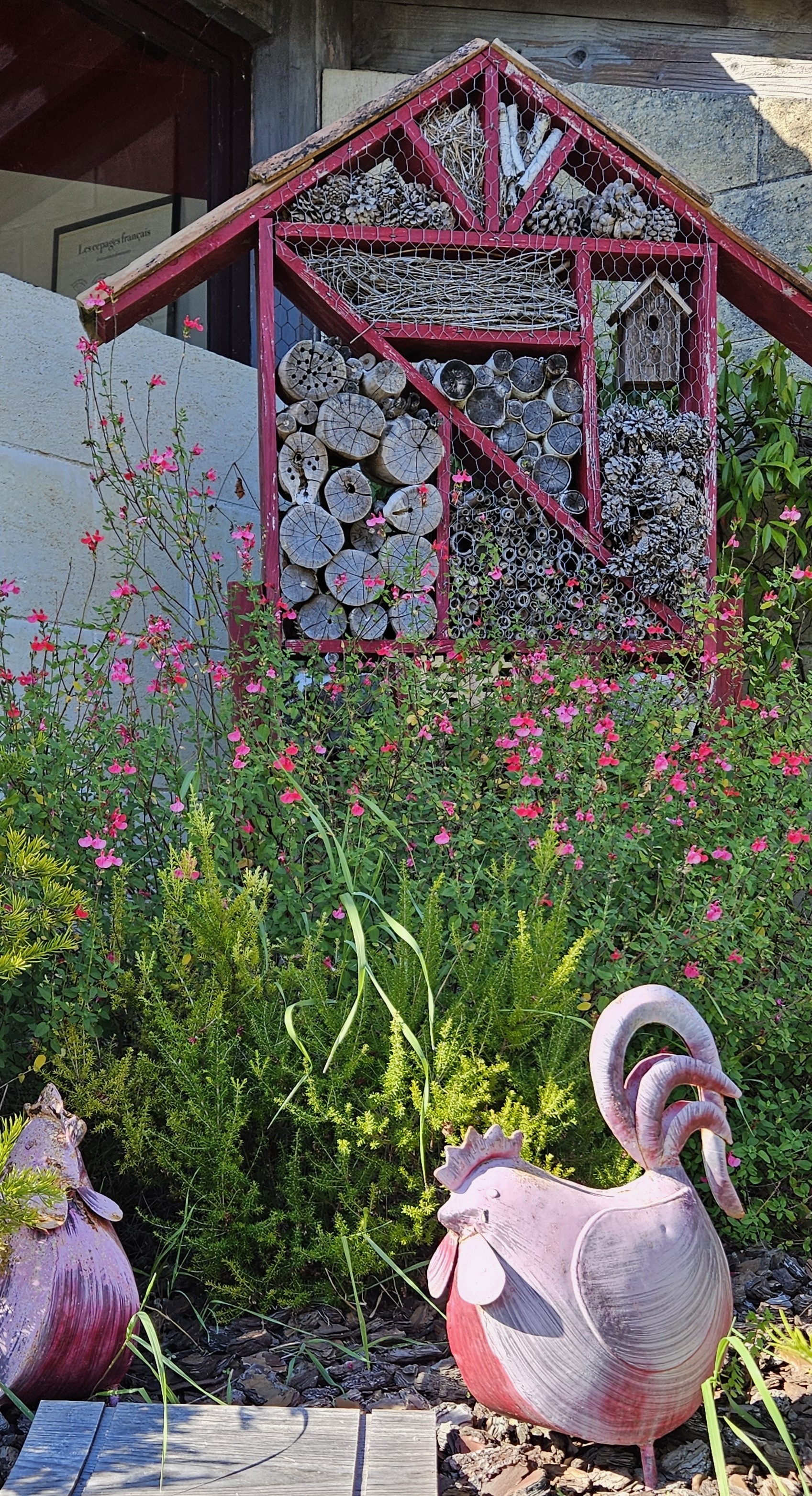 Flower patch with insect house and sculptural chickens