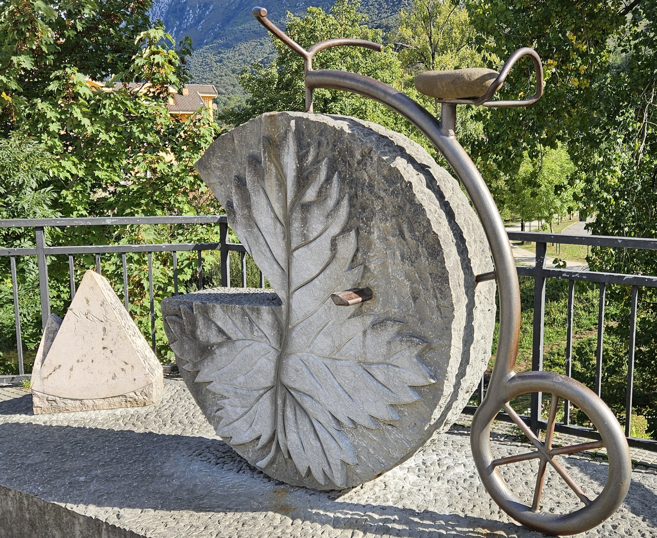 Big-wheel bicycle sculpture with stone cheese for wheel
