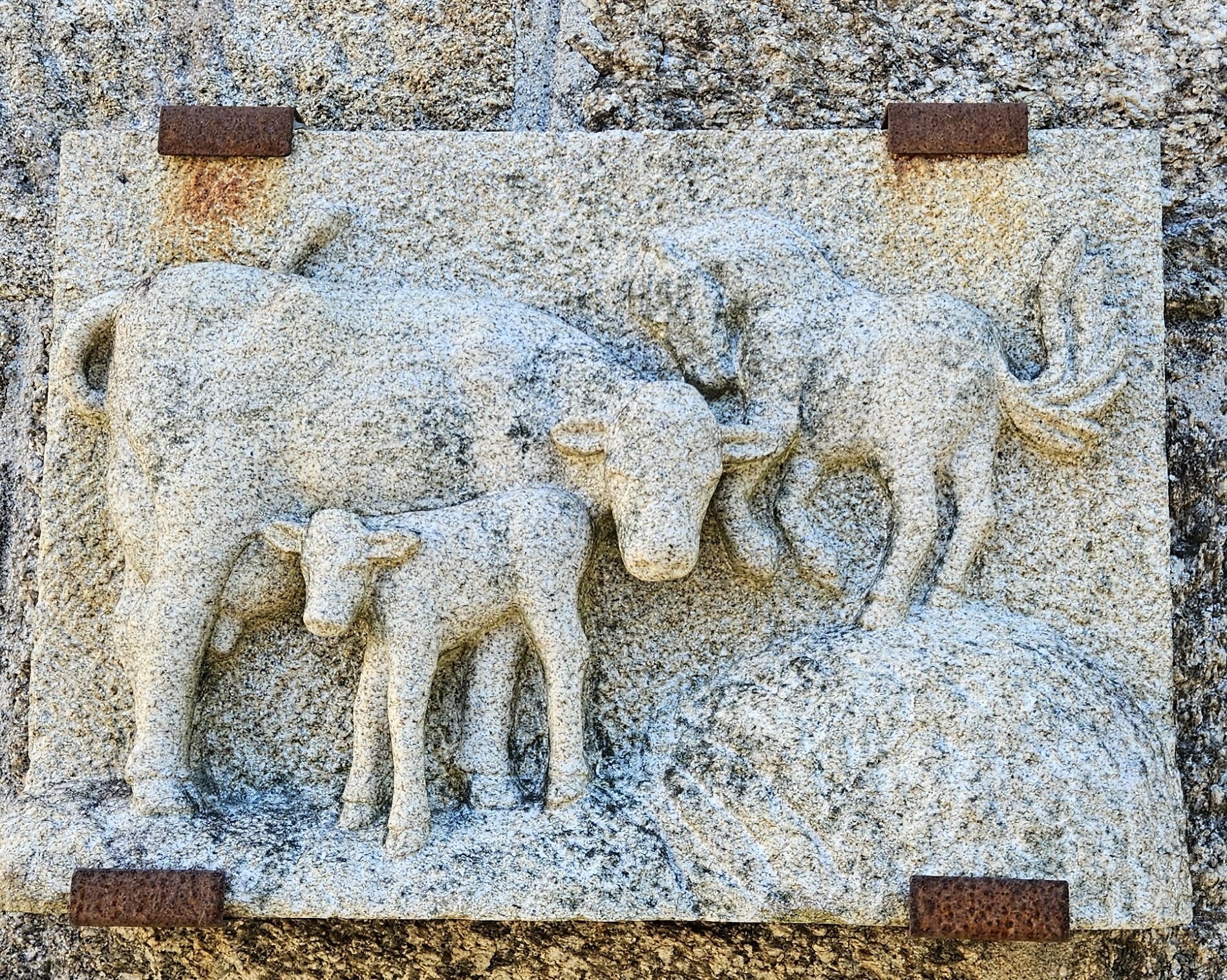 Relief sculpture of cow, calf, and horse at the market