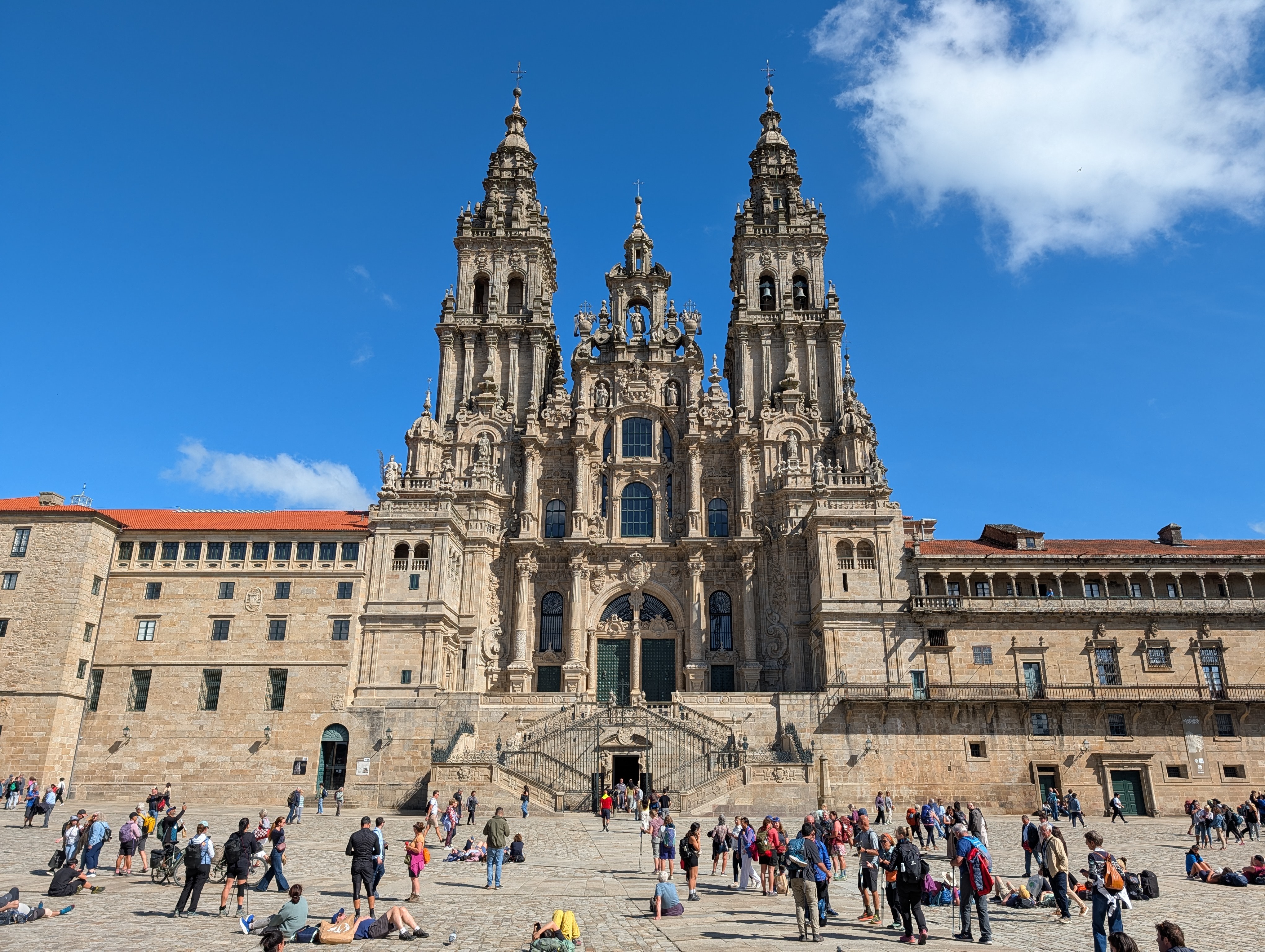 Cathedral of Santiago de Compostela with wearing pilgrims resting on plaza