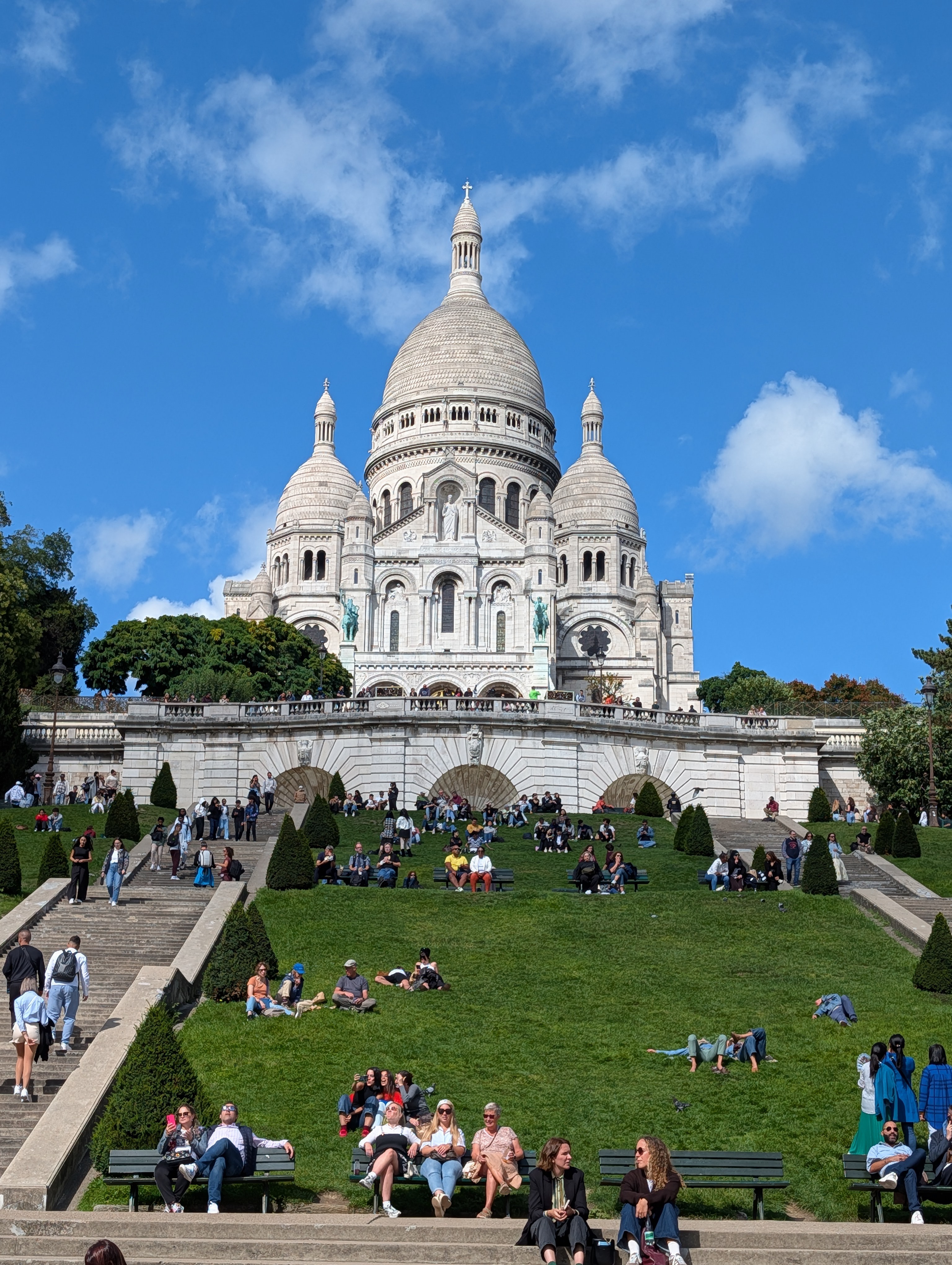People enjoying the weather on the terraced lawn of Sacre-Coeur