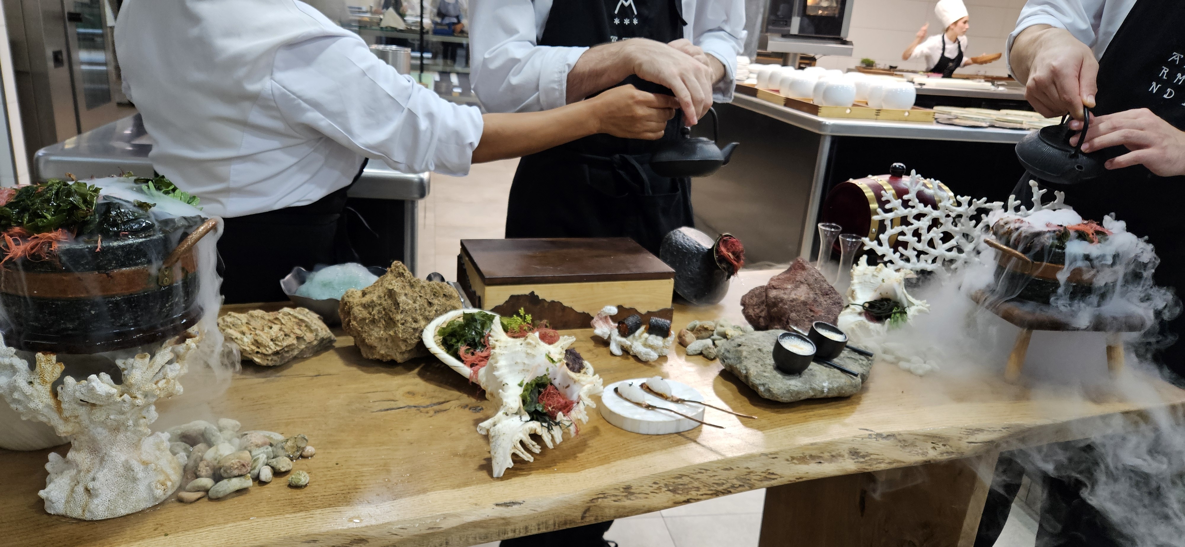 Table with seafood bites and dry ice pots set with seashells