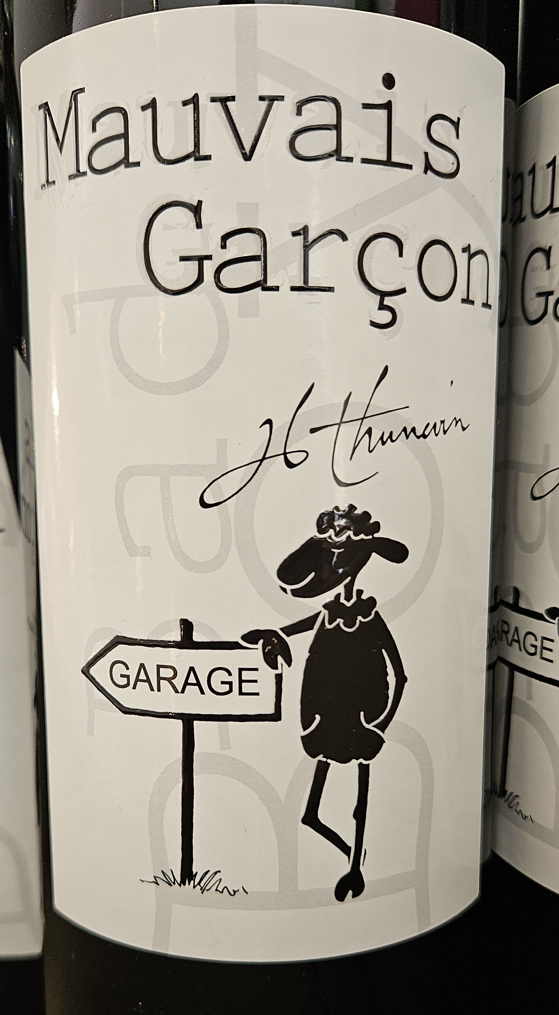 Wine label with cute sheep leaning on sign pointing to the Garage