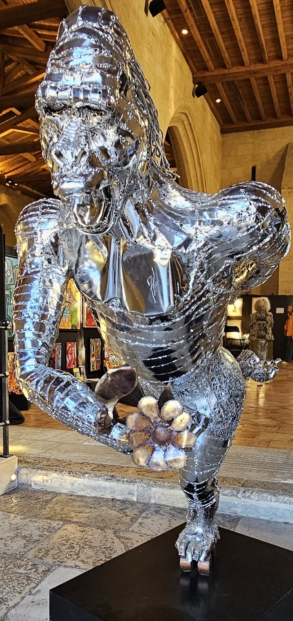 Bold mirrored sculpture of gorilla offering flowers